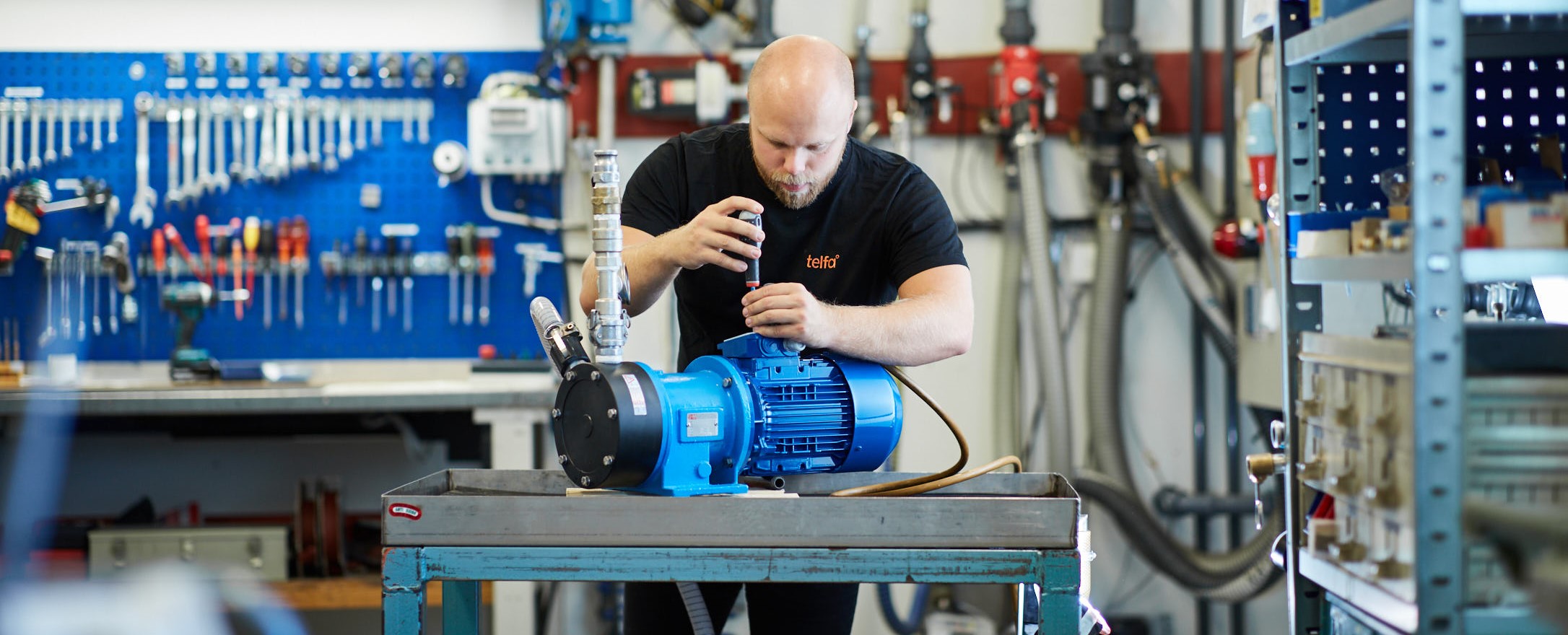 En mekaniker som skruvar i Telfas verkstad